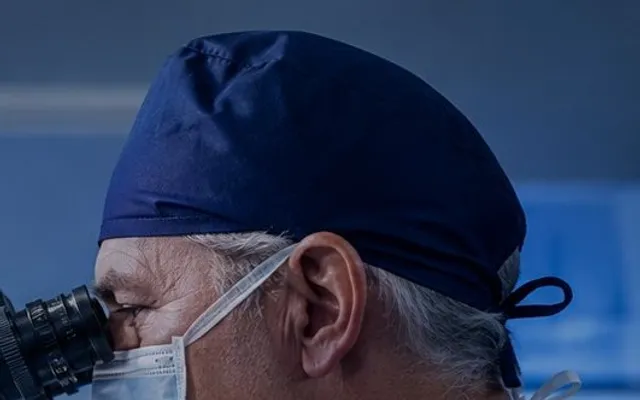 Ear surgeon at the operating microscope